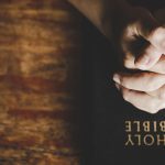 Praying hands over the Bible